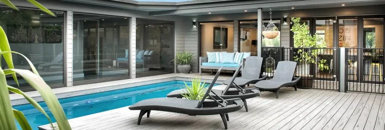 External wide shot of a large uPVC window overlooking the outdoor pool and sunbed