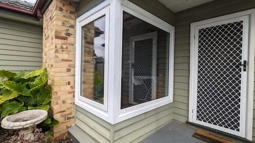 Medium close up shot of outdoor uPVC window next to the front door of a home in Australia